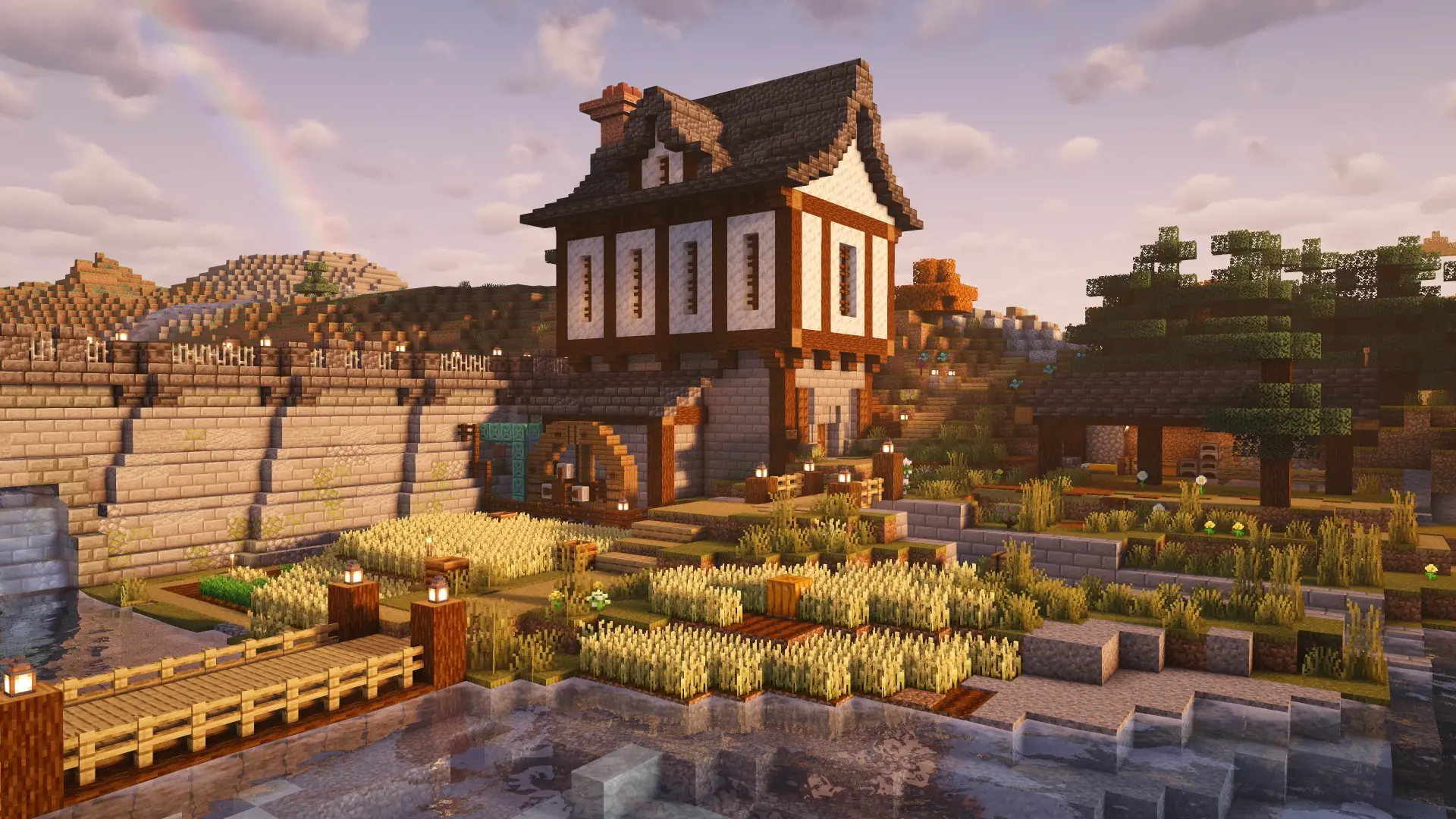 A timber-framed Minecraft watermill beside wheat fields, a wooden bridge, and a river